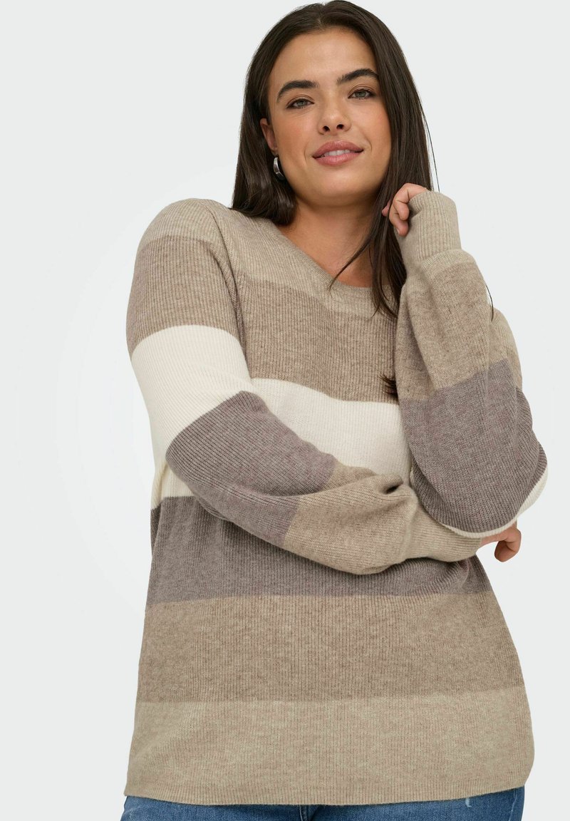 Beige and brown striped sweater with a V-neck, long sleeves, ribbed texture, and a relaxed fit. Worn with blue denim jeans.
