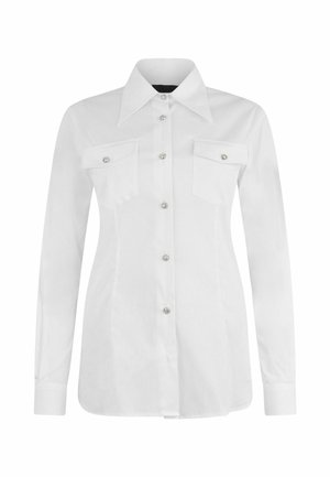 Camicia bianca a maniche lunghe realizzata in tessuto morbido, con colletto a punta, due tasche sul petto e bottoni decorativi.