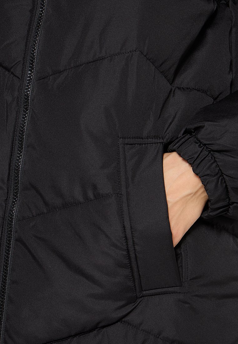 Schwarze gepolsterte Jacke mit Reißverschluss, seitlichem Taschen und elastischen Bündchen. Glatte Textur mit einem gesteppten Muster.