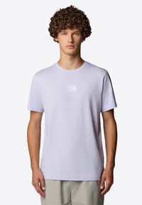 Jasnofioletowa bawełniana koszulka z okrągłym dekoltem i krótkimi rękawami. Posiada małe białe logo na piersi. Gładka tekstura; luźny krój.