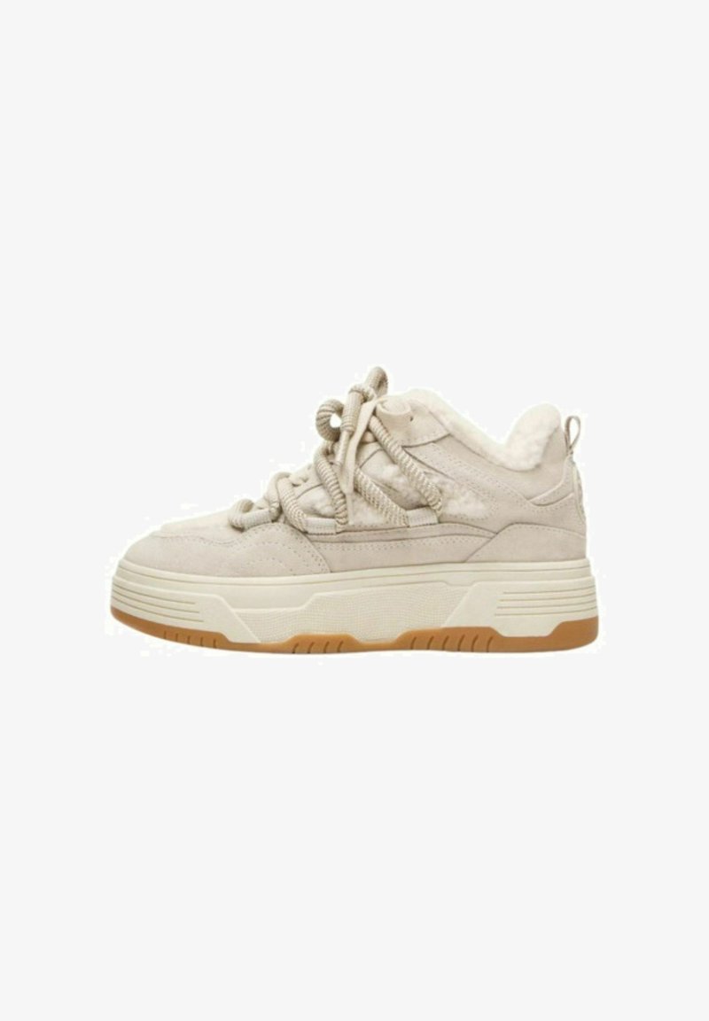 Sneaker beige in suede con una robusta suola bianca, pannelli laterali testurizzati e lacci decorativi. Presenta un morbido rivestimento interno e un resistente tallone.