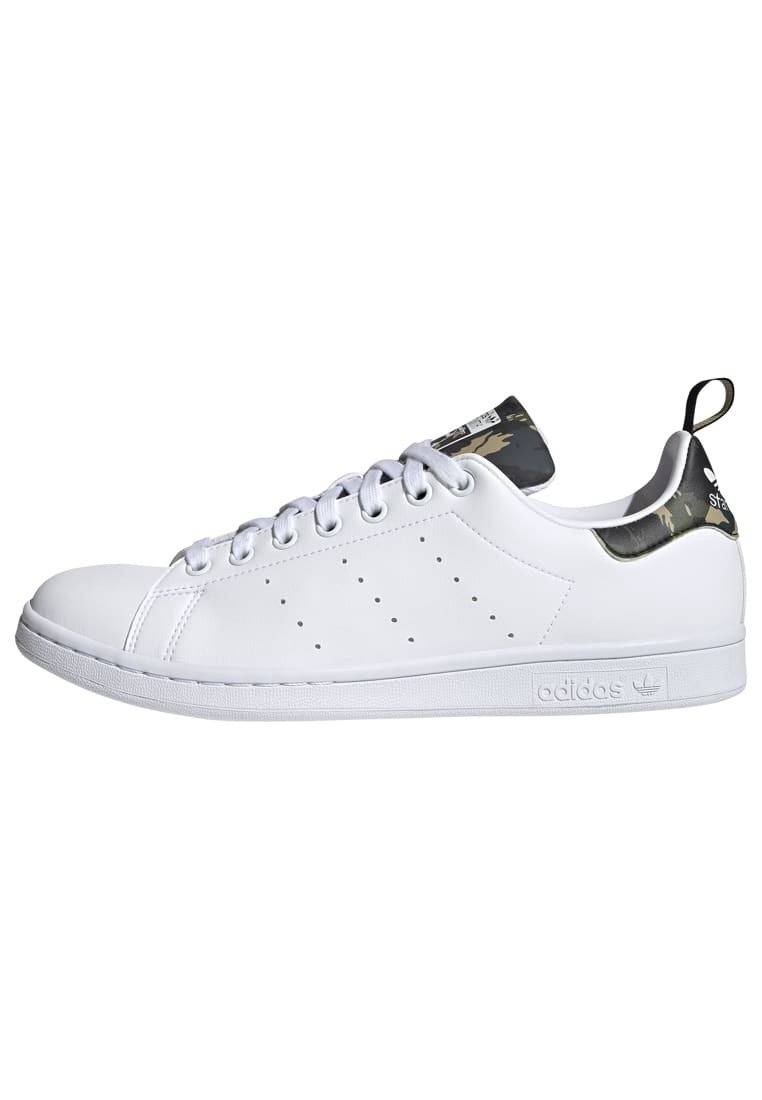 Vit lädersneaker med rund tå, platt gummisula, perforerade sidodetaljer och kamouflagemönstrad accent på hälfliken.