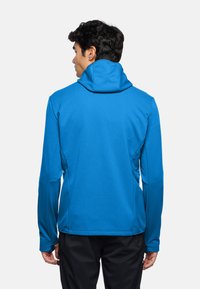 Felpa con cappuccio di un vivace blu, con collo alto, maniche lunghe e una texture liscia. Presenta una silhouette aderente e un design senza cuciture.