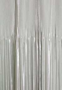 Tessuto plissettato argento con una texture metallica lucida. Le scanalature verticali creano un aspetto fluido e morbido. Superficie morbida e riflettente.