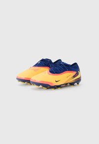 Nike football boots feature a yellow and orange gradient upper with blue accents, textured surface, and molded studs for traction.