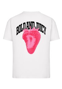 Hvit t-skjorte med et stort rosa jordbærgrafikk og teksten "BOLD AND JUICY" i fet svart skrift på baksiden.