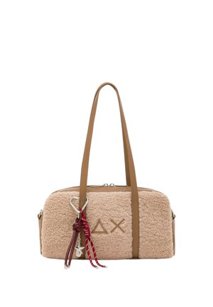 Pequeño bolso rectangular beige y esponjoso con asas marrones, decorado con cordones rojos y un colgante de estrella plateada en el frente.