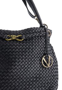 Czarna pleciona skórzana torba z ozdobnym splotem, złotym metalowym wykończeniem oraz okrągłą zawieszką z logo. Teksturowana powierzchnia dodaje głębi.