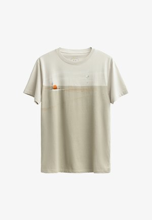 Beige katoenen t-shirt met een minimalistische strandscène print, featuring een oranje stoel, een rode cirkel en lichtblauwe accenten. Korte mouwen, ronde halslijn.