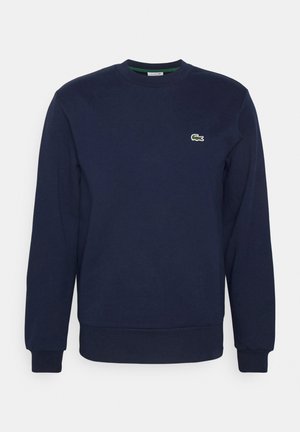 Felpa blu navy in misto cotone, con colletto a girocollo, polsini a costine e un piccolo logo ricamato sul petto. Vestibilità regolare.