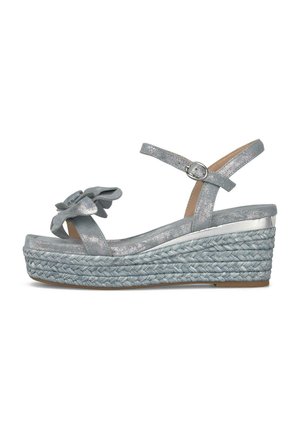 Sandalia de cuña plateada con suela de plataforma trenzada, correa al tobillo con hebilla y detalle decorativo de flor en la correa del dedo.