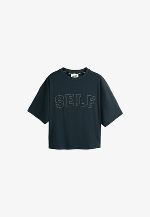 Schwarzes kurz geschnittenes T-Shirt mit kurzen Ärmeln und dem Wort "SELF", das in großen Umrissbuchstaben quer über der Brust gestickt ist.
