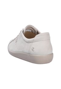 Witte lage sneaker met vetersluiting aan de voorkant, zachte leren bovenkant en beige rubberen zool, gezien vanuit een achteraanzicht op een witte achtergrond.