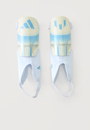 Paire de protège-tibias Adidas bleu et blanc à l'effigie de Messi avec des sangles élastiques pour la cheville sur un fond uni.