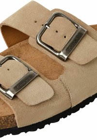 Sandale en daim beige avec deux brides ajustables, boucles argentées et une semelle intérieure en liège. Semelle extérieure en caoutchouc noir texturé pour une bonne adhérence.