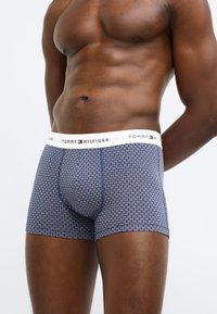 Tommy Hilfiger navyblå boxershorts med et lille hvidt geometrisk mønster, med hvid linning med logo. Fremstillet af strækbar bomuldsblanding.