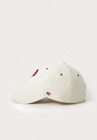 Hvit cordfløyels baseballcap med en rød brodert logo på forsiden og '47' brodert på siden. Buet skygge og seks-panel konstruksjon.