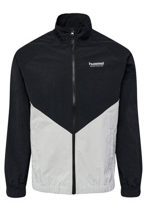 Black and white windbreaker jacket with a high collar, zip closure, and elastic cuffs; features a diagonal color block design and logo.
