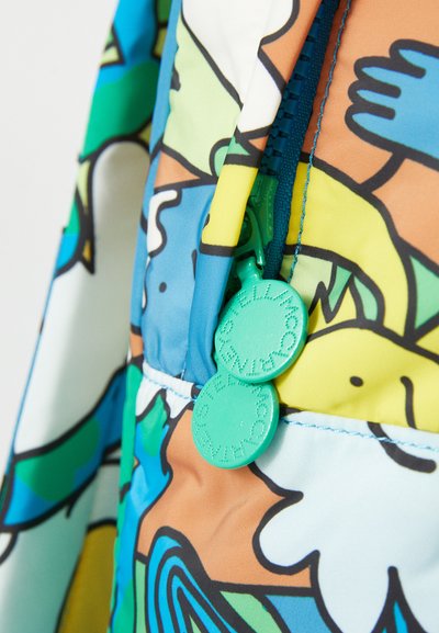 Jachetă cu fermoar colorată, având un model abstract vibrant în nuanțe de albastru, verde și portocaliu; detaliile hardware includ mânerele rotunde ale fermoarului de culoare verde.