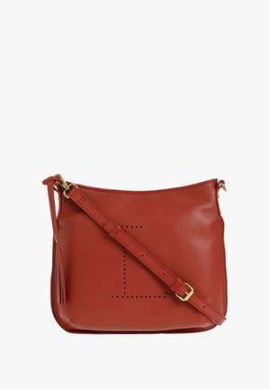 Sac en cuir en rouges avec une texture lisse, des accessoires en or, une bandoulière ajustable et des détails perforés dans un motif géométrique.