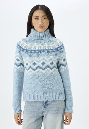 Light blue knitted sweater with a high collar. Features a patterned yoke in darker blue and white geometric designs. Soft, textured fabric.