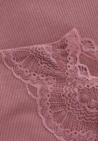 Ribbade tyger i mjuk mauve med delikat spetskant som har intrikata mönster och vågiga kanter. Den övergripande texturen är slät och lager-på-lager.