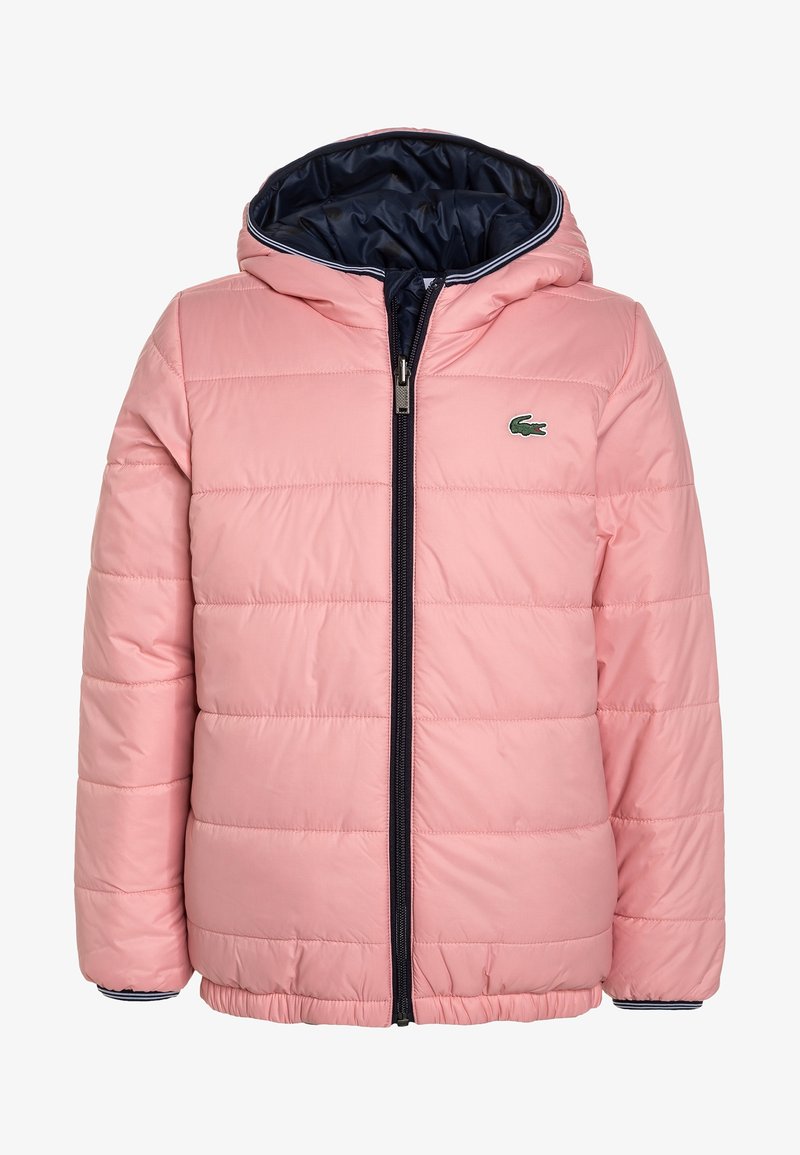 Veste matelassée rose à capuche avec fermeture éclair noire et logo crocodile vert sur la poitrine, doublure intérieure bleu marine et poignets rayés.