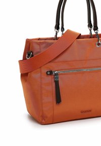 Orangefarbene Nylon-Handtasche mit zwei schwarzen Griffen, verstellbarem Schultergurt, Frontreißverschlusstasche mit Quaste und glatter, eleganter Oberfläche.