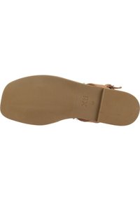 Suela de zapato marrón claro con una superficie texturizada y acanalada y un tacón ligeramente elevado. Marcada con "Xti" y tamaño "38". Diseño plano.