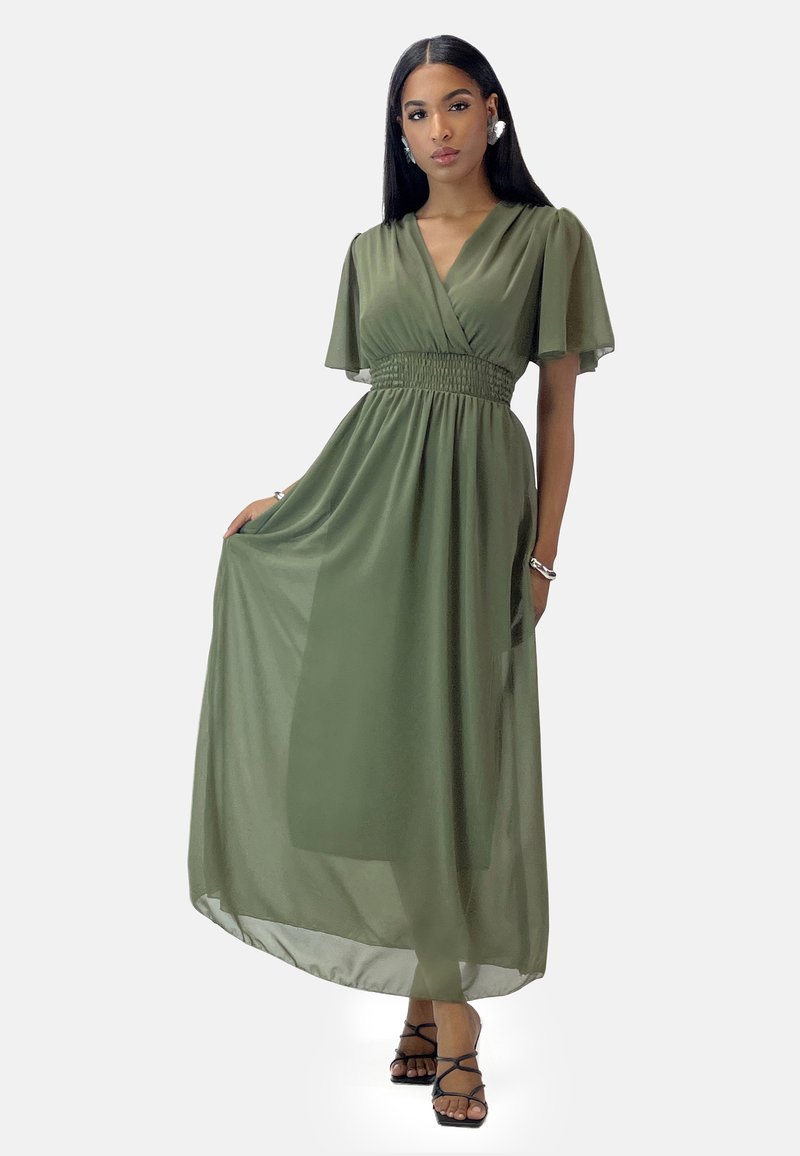 Robe maxi vert olive avec un décolleté en V croisé, des manches volantées et une taille smockée. Tissu transparent avec une silhouette fluide et une texture légère.