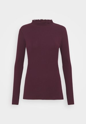 Pull prune à manches longues, côtelé, avec un col montant à volants, une silhouette ajustée et une texture tricotée lisse.