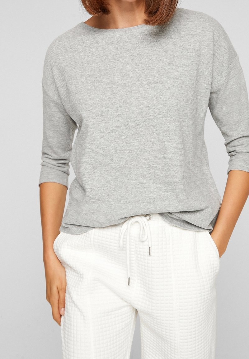 Gray long-sleeve top with a relaxed fit and soft texture, paired with white, textured drawstring pants featuring a quilted pattern.