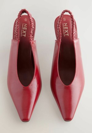 Scarpe slingback in pelle rossa con punta appuntita, presentano elastiche arricciate sul retro, texture liscia e un soletta comodamente imbottita.
