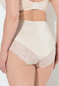 Mutande beige a vita alta con tessuto a coste e bordi in pizzo scallop, caratterizzate da una trama morbida e un delicato motivo floreale.