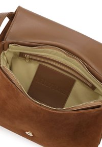 Interno della borsa in pelle marrone e suede, con foderatura beige, tasca con zip e portacard in rilievo "EDITIONS". Dettagli con cerniera dorata inclusi.