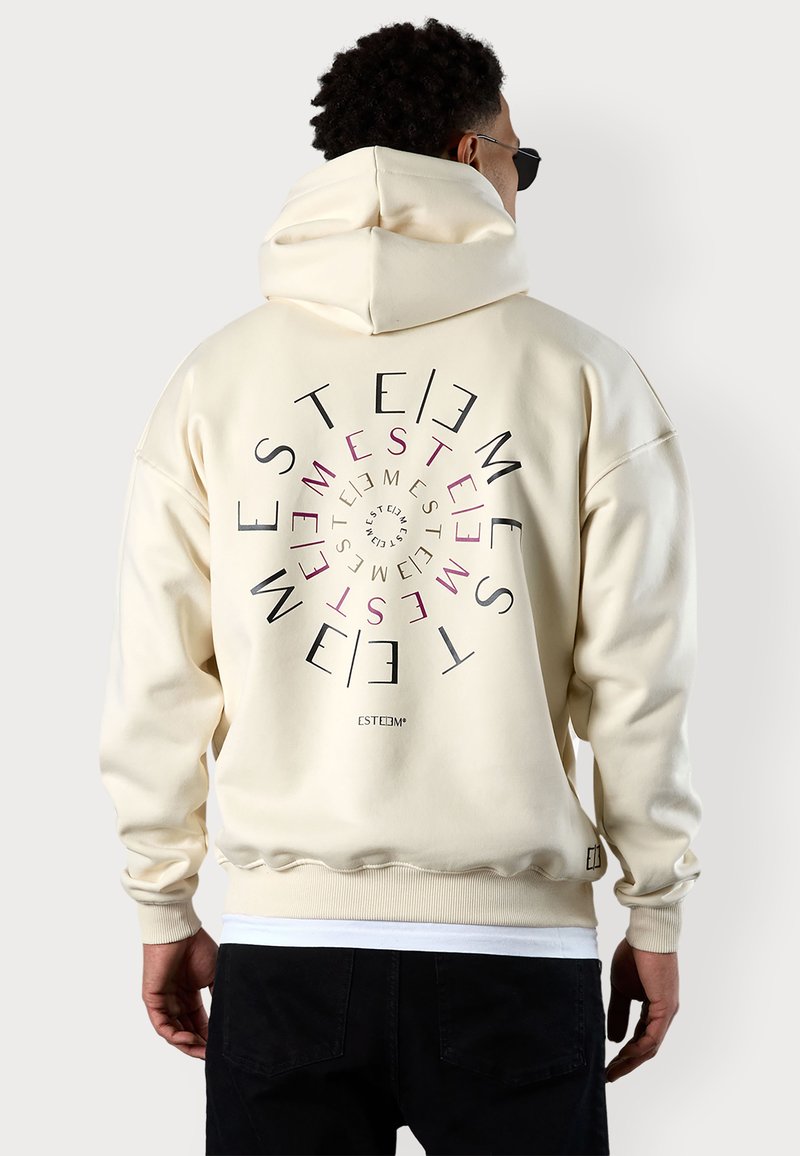 Cream-colored hoodie with a spiral text design on the back in black and pink, made of soft material, featuring a large hood and ribbed cuffs.