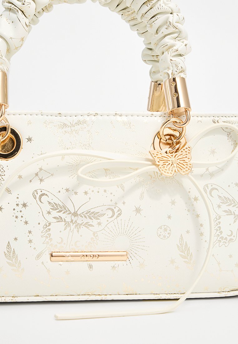 Sac à main blanc texturé avec des motifs en or de papillons et d'étoiles, rehaussé d'une poignée tressée et de quincailleries dorées. Présente un nœud décoratif.