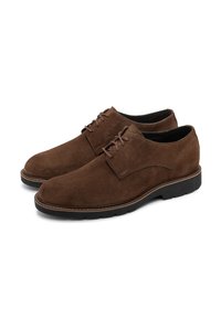 Chaussures derby pour hommes en daim marron, à lacets, avec des semelles en caoutchouc noires, présentées en paire sur fond blanc.