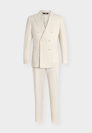 Completo composto da blazer doppiopetto color crema con trama e pantaloni abbinati, esposto su uno sfondo chiaro semplice.