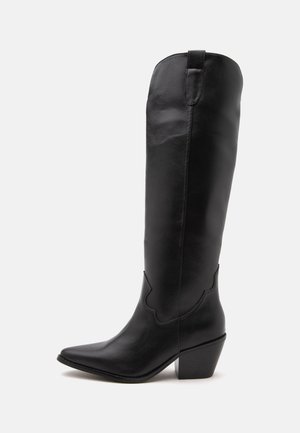Botte de cowboy haute en cuir noir avec un bout pointu, un talon bas et des coutures minimales, présentée de côté sur fond blanc.
