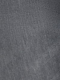 Texture de tissu gris avec un motif de tissage subtil et fin et de légères variations d'ombrage.
