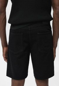 Zwarte denim shorts met een rechte snit, twee achterzakken en een gladde textuur. Het ontwerp heeft minimale details en een strakke afwerking.