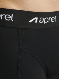 Schwarze Herrenunterwäsche mit einem schwarzen Bund, der weiße Buchstaben trägt, die "aprel" lesen. Glatte Textur mit sichtbaren Nähdetails.