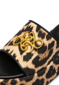 Ciabatta slide con stampa leopardata e base nera, caratterizzata da un elemento decorativo dorato prominente sulla cinghia superiore. Design piatto e open-toe.