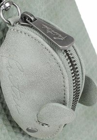 Borsetta in pelle testurizzata verde chiaro con una cerniera argentata, caratterizzata da una forma rotonda e una piccola patta con dettagli che ricordano delle orecchie.