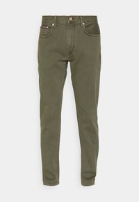 Olivově zelené slim-fit džíny s pěti kapsami, zapínáním na knoflík a zip a jemnými švy na stranách. Bavlněná textura látky.