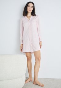 Robe de nuit à manches longues à carreaux roses avec un bouton sur le devant et une poche poitrine, fabriquée en tissu léger au toucher doux.