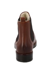 Stivale Chelsea in pelle marrone con pannelli elastici, fodera morbida e suola nera robusta. Presenta un tassello in tan sul tallone e dettagli di cucitura.