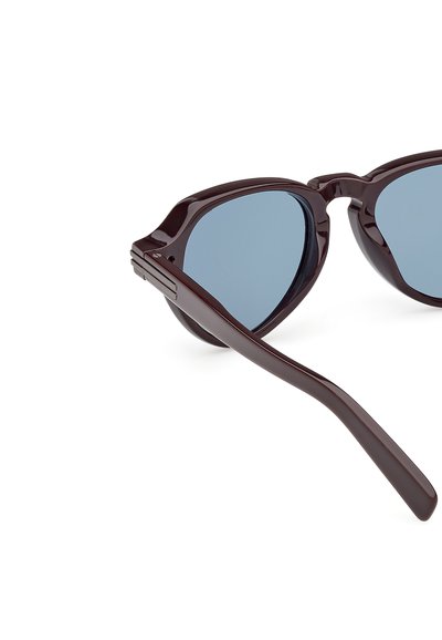 Burgundské plastové sluneční brýle s modrými skly; tvar kočičích očí, hladký povrch a štíhlé nožičky s jemným zdobením na panty.