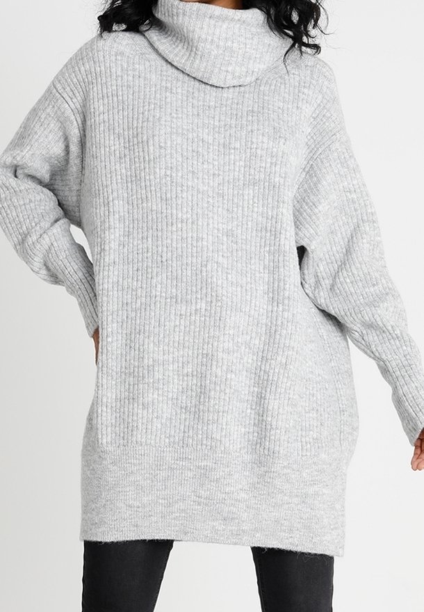 Vaaleanharmaa, ribattu neulepusero, jossa on ylisuurta, rentoa istuvuutta ja pitkät hihat. Puserossa on huomaamaton tekstuuri ja suora helma.